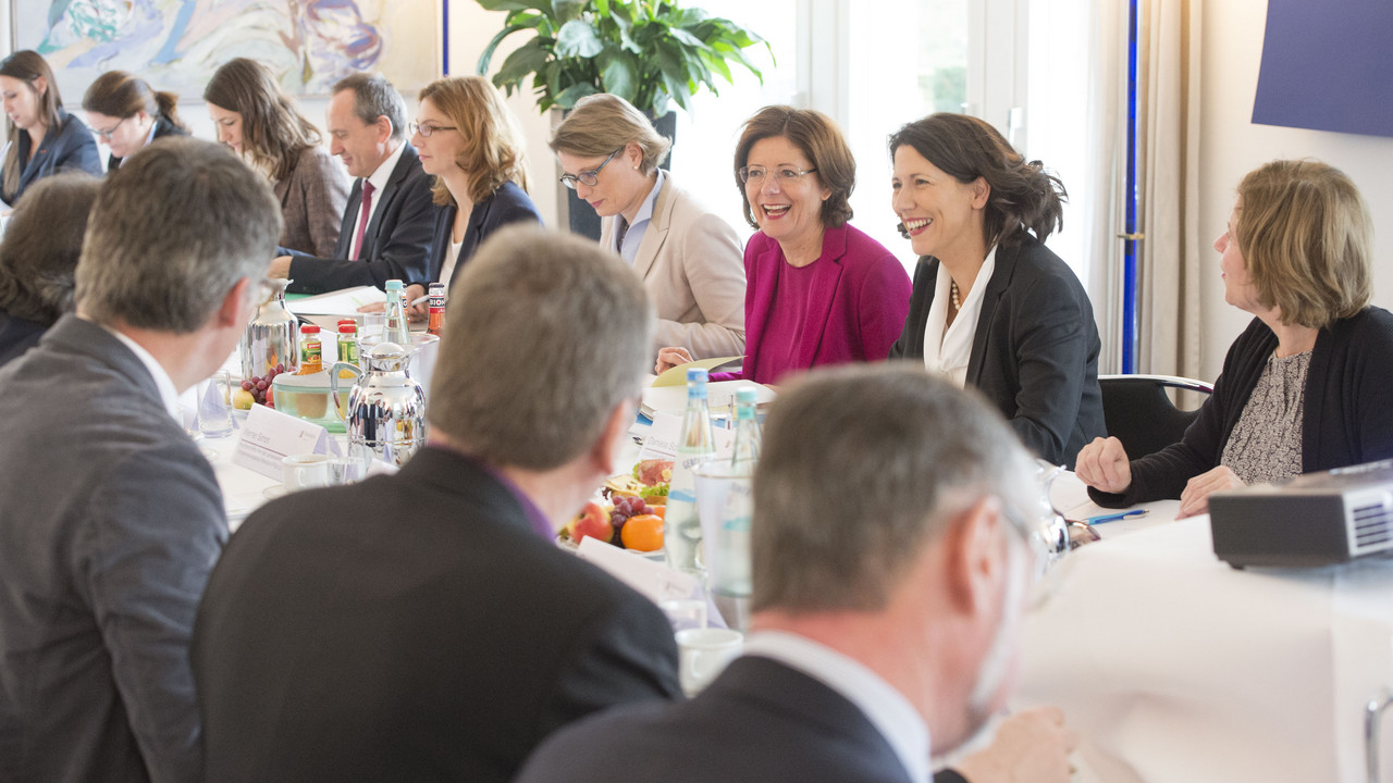 Die Teilnehmerinnen und Teilnehmer des Ovalen Tisches sitzen im Gästehaus der Landesregierung an einem Tisch zusammen