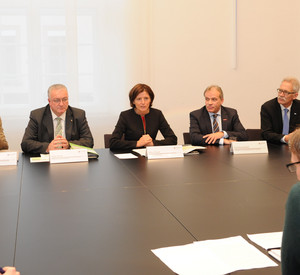 Die Teilnehmerinnen und Teilnehmer des Ovalen Tisches sitzen im November 2015 zur Besprechung zusammen.